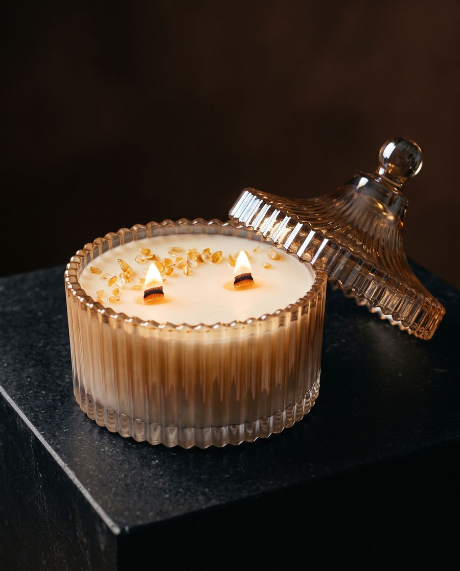 Prosperity
 candle by Lili & Koi, Amber & Jasmine
, lit on dark stone